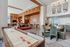 A stylish resident lounge featuring a mix of seating areas including plush armchairs, a communal high-top table, built-in shelving, and modern lighting in a spacious, light-filled room.