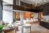 Open-concept coworking area with a marble-front desk, plush lounge seating, decorative lighting, and private glass-walled meeting rooms.
