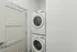 Compact laundry area with stacked washer and dryer in a modern apartment.