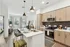 Modern open-plan kitchen with stylish cabinetry and cozy living area with natural light.