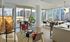 Chic modern living room with large windows offering a panoramic city view, stylish furniture, and wooden floors.