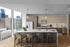 Chic and modern kitchen with a spacious island, elegant lighting, and panoramic city views.