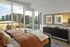 Chic bedroom with modern decor, large windows offering stunning cityscape views.