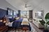Modern bedroom with a large window offering a cityscape view, featuring elegant decor and a cozy setup.