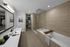Elegant bathroom featuring a modern vanity, glass shower, and bathtub with wooden accent.