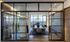Elegant dining area with floor-to-ceiling windows and a modern chandelier, offering city views.