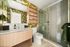 Elegant bathroom featuring a vibrant green bird-themed wallpaper, sleek glass shower, and modern wood cabinetry.