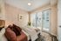 Inviting bedroom with modern decor, featuring a cozy bed, stylish artwork, and a balcony view.