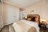 Elegant bedroom with stylish decor, featuring a comfortable bed with brown cushions and a modern side table with a lamp.