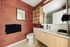 Contemporary bathroom featuring geometric red wallpaper, sleek vanity, and modern fixtures.
