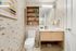 Chic bathroom featuring modern fixtures, stylish wallpaper, and wooden shelving for storage.