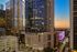 Stunning high-rise building illuminated during sunset in a vibrant cityscape.