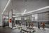 Modern gym with advanced equipment, floor-to-ceiling windows, and stylish lighting, offering a premium workout space.