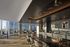 Stylish open-plan apartment with panoramic city views, featuring modern decor and a sleek kitchen.