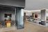 Sleek and modern apartment featuring a stylish dining area with a wooden table and a spacious living room with a plush gray sofa.