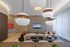 Stylish modern lounge featuring elegant pendant lights, chic decor, and a cozy seating arrangement.
