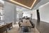 Sleek contemporary lounge area with a long dining table, plush chairs, and ambient lighting.