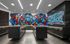 Dynamic mailroom with colorful abstract mural and sleek black mailboxes.