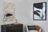 Sophisticated corner view with modern art, sleek lamp, and plush armchair.