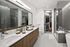 Elegant bathroom with double sink vanity, glass-enclosed shower, and walk-in closet.