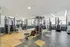 Modern fitness center with state-of-the-art gym equipment, featuring ample natural light and spacious layout.