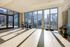 Bright and inviting fitness room with panoramic city views, featuring stationary bikes and vibrant dumbbell racks.