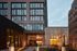 Modern and elegant apartment building exterior showcasing sleek architecture with large windows and landscaped entryway.