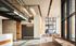Modern lobby with sleek glass railing mezzanine, natural wood accents, and vibrant artwork, offering a stylish and welcoming atmosphere.
