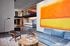 Modern apartment lobby with contemporary furniture, vibrant artwork, and open mezzanine design.