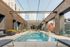 Chic urban rooftop pool with sleek lounge chairs surrounded by city skyline views, perfect for relaxation.