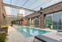 Chic city rooftop pool with stylish lounge chairs and stunning urban views, perfect for a relaxing escape.