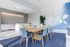 Contemporary meeting space with a large wooden table, stylish blue chairs, modern decor, and ambient lighting.