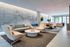 Modern living space featuring stylish seating, a sleek pool table, and large windows overlooking greenery.