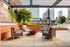 Chic urban rooftop patio with cozy seating and a central fire pit, offering stunning cityscape views.