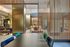 Modern open-plan living space with sleek furniture, stylish wooden partitions, and elegant lighting accents.
