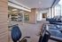Spacious and modern gym with state-of-the-art treadmills and a fully equipped weight rack, perfect for fitness enthusiasts.