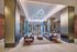 Elegant lobby with modern geometric lighting, stylish seating area, and sleek decor.