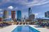 Luxurious rooftop pool with stylish lounge chairs and stunning skyline views, perfect for relaxation and enjoying the cityscape.