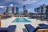 Luxurious rooftop pool with stylish lounge chairs and skyline views, offering an urban oasis in the heart of the city.
