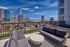 Breathtaking cityscape views from a luxurious apartment terrace with stylish outdoor seating overlooking a vibrant skyline and river.