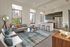 Contemporary open-concept apartment featuring a cozy living area with city views, modern kitchen, and stylish furnishings.