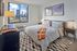 Chic bedroom with stunning cityscape views, featuring contemporary decor, large window, and elegant furnishings.