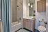 Elegant bathroom featuring modern fixtures, sleek vanity, and relaxing bathtub with soft blue accents.