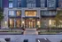 Elegant facade of a modern apartment building with large windows and warm lighting, offering luxurious urban living.