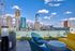 Chic rooftop terrace with modern seating offering stunning skyline views and blue skies.