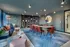 Modern communal space with stylish seating, vibrant art, and a spacious wooden table perfect for gatherings.