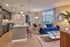 Modern open-plan apartment with chic kitchen, cozy living area, and large windows showcasing scenic views.