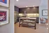 Modern kitchen with sleek cabinetry, stainless steel appliances, and a chic dining nook accented by elegant artwork.
