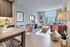 Chic, modern living and dining area with natural light, featuring elegant furniture, tasteful decor, and stunning city views.