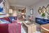 Chic and modern apartment living room with stylish decor, featuring a plush red sofa, elegant dining area, and sleek kitchen design.